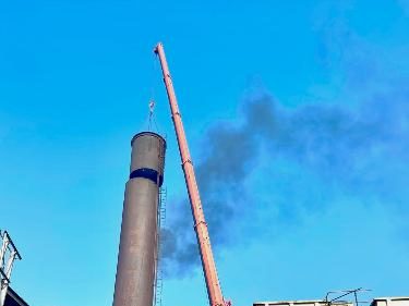 Boiler stack with crane boom alongside